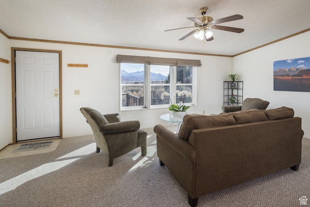 carpeted living room featuring crown molding, ceiling fan, a mountain view, and a textured ceiling
