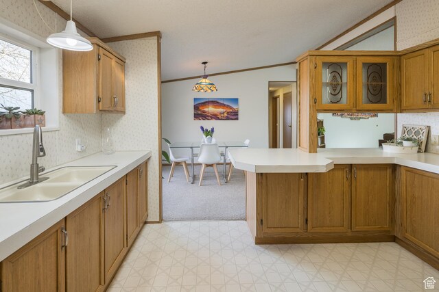 kitchen with pendant lighting, crown molding, kitchen peninsula, and sink