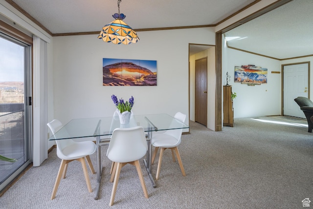 dining area featuring ornamental molding and carpet flooring