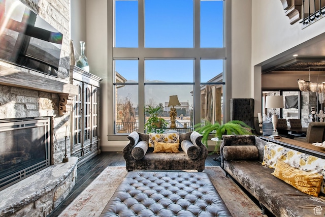 9632 N 5650 W, Highland, UT 84003 - living room with dark wood-type flooring, a towering ceiling, a stone fireplace, and a notable chandelier