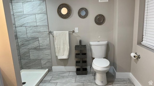 bathroom with tiled shower and toilet