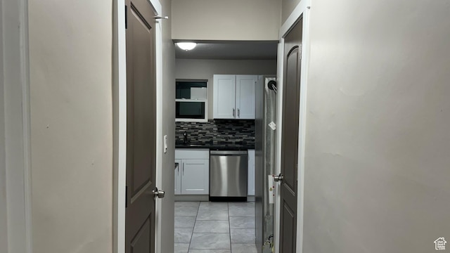 kitchen featuring white cabinetry, stainless steel dishwasher, and decorative backsplash