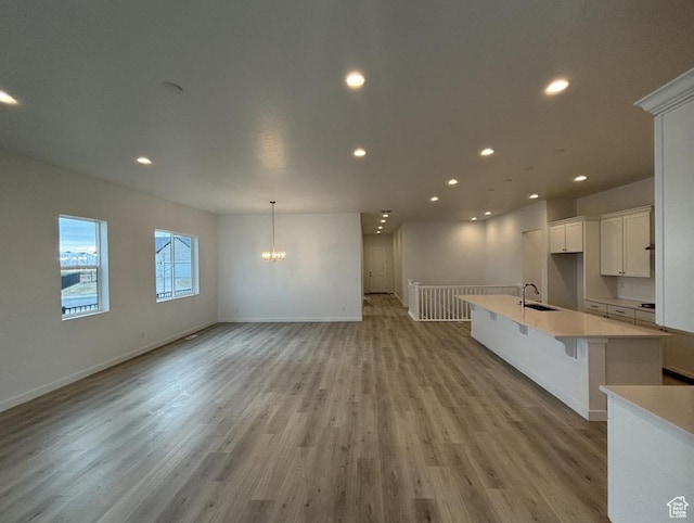284 E Polaris Dr Unit 112, Saratoga Springs, UT 84045 - unfurnished living room with sink, light hardwood / wood-style flooring, and a chandelier
