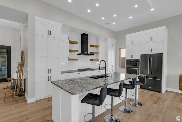 2090 N Tuweap Dr Unit 56, St George, UT 84770 - kitchen featuring an island with sink, appliances with stainless steel finishes, sink, and wall chimney range hood