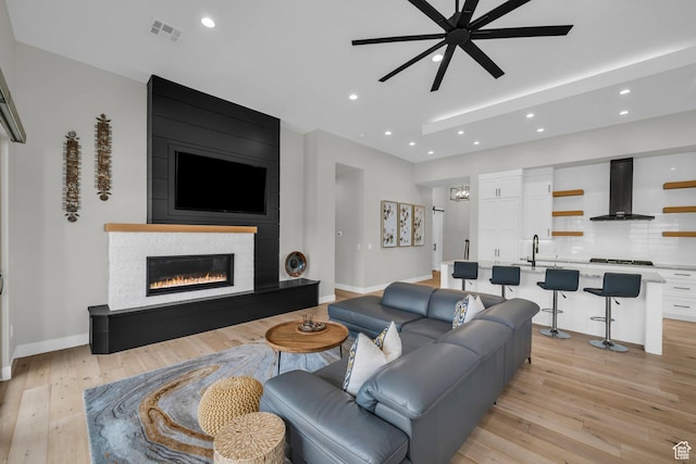 2090 N Tuweap Dr Unit 56, St George, UT 84770 - living room with a large fireplace, sink, ceiling fan, and light hardwood / wood-style flooring