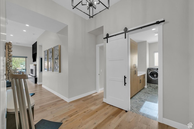 2090 N Tuweap Dr Unit 56, St George, UT 84770 - hall featuring washer / clothes dryer, a barn door, and light wood-type flooring