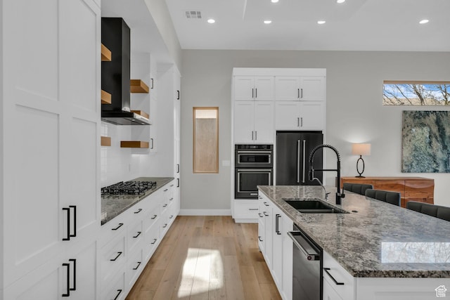 2090 N Tuweap Dr Unit 56, St George, UT 84770 - kitchen with sink, white cabinetry, a kitchen island with sink, black appliances, and wall chimney exhaust hood