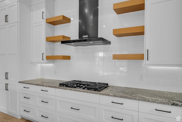 2090 N Tuweap Dr Unit 56, St George, UT 84770 - kitchen featuring wall chimney range hood, black gas stovetop, light stone countertops, and white cabinets