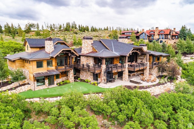8435 N Ranch Garden Rd, Park City, UT 84098 - back of house featuring stone siding, a chimney, a standing seam roof, and metal roof