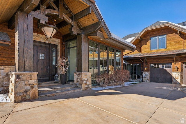 8435 N Ranch Garden Rd, Park City, UT 84098 - property entrance featuring stone siding, an attached garage, concrete driveway, and a gate