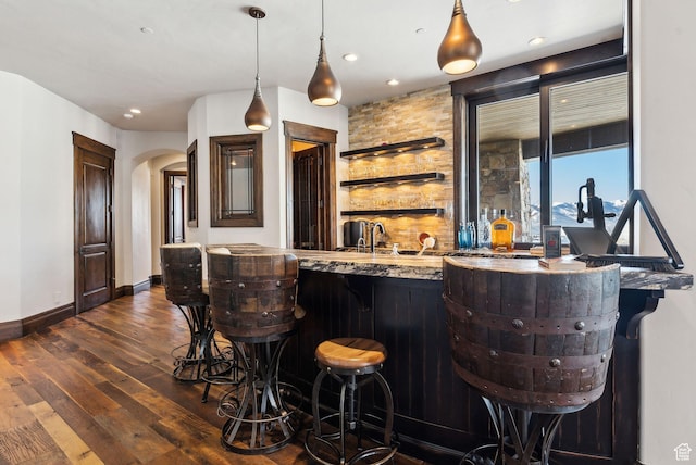 8435 N Ranch Garden Rd, Park City, UT 84098 - indoor wet bar featuring dark wood-style flooring, arched walkways, baseboards, recessed lighting, and hanging light fixtures