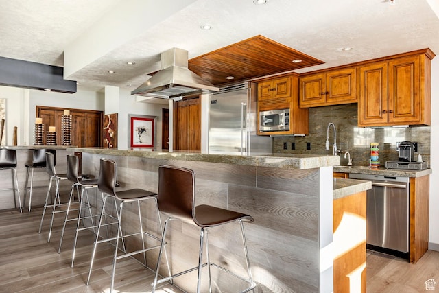 751 Main St Unit 415, Park City, UT 84060 - kitchen featuring sink, light hardwood / wood-style flooring, a kitchen breakfast bar, built in appliances, and island exhaust hood