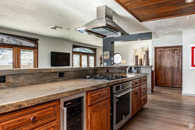 751 Main St Unit 415, Park City, UT 84060 - kitchen featuring island range hood, wood-type flooring, a textured ceiling, stainless steel appliances, and beverage cooler