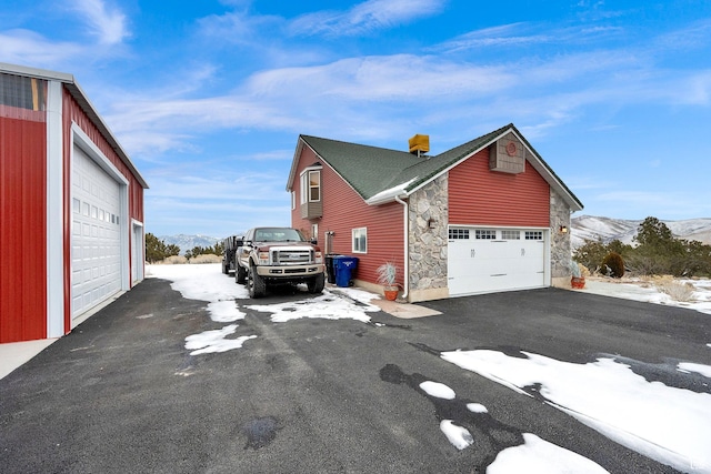 view of snow covered exterior featuring a mountain view and a garage