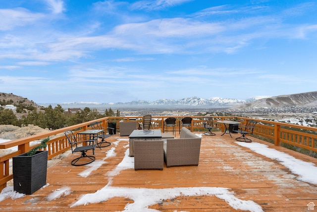 snow covered deck with a mountain view and outdoor lounge area