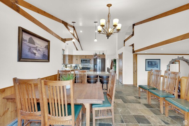 dining space with high vaulted ceiling and a chandelier
