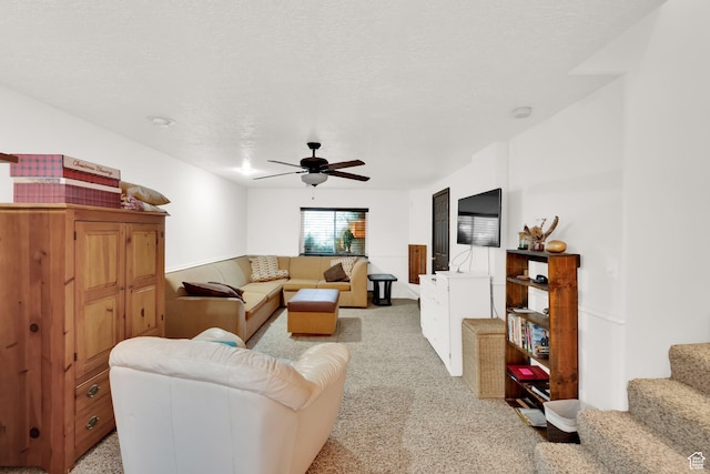 carpeted living room featuring a textured ceiling and ceiling fan