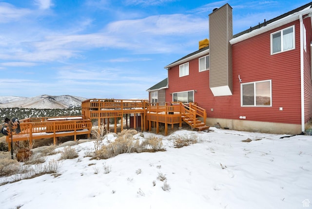 snow covered property featuring a deck with mountain view