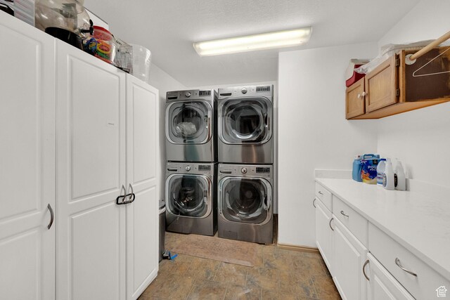 laundry area featuring cabinets and stacked washer / dryer