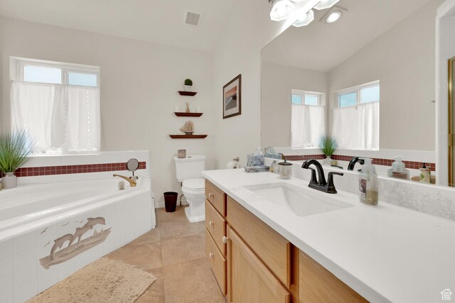 bathroom with lofted ceiling, tiled bath, tile patterned flooring, vanity, and toilet