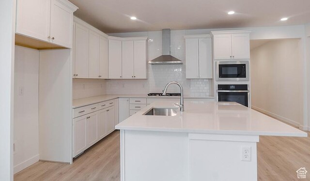 5398 N Pony Rider Way Unit 420, Eagle Mountain, UT 84005 - kitchen featuring oven, an island with sink, a sink, wall chimney range hood, and built in microwave