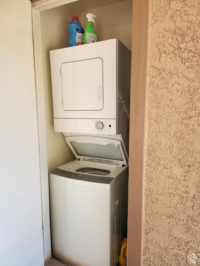 laundry room with stacked washing maching and dryer