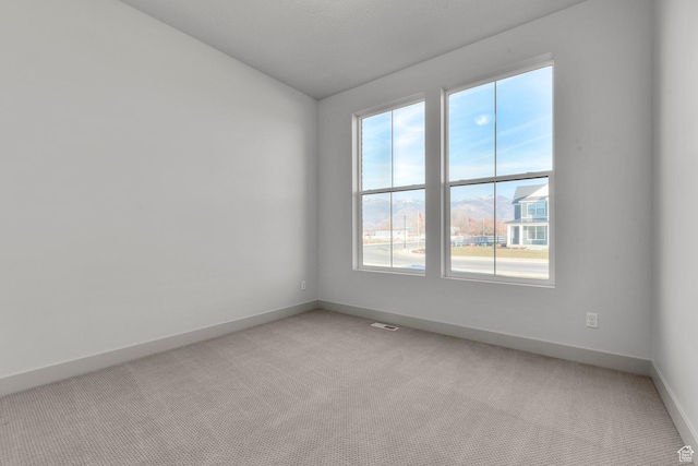 carpeted spare room featuring vaulted ceiling