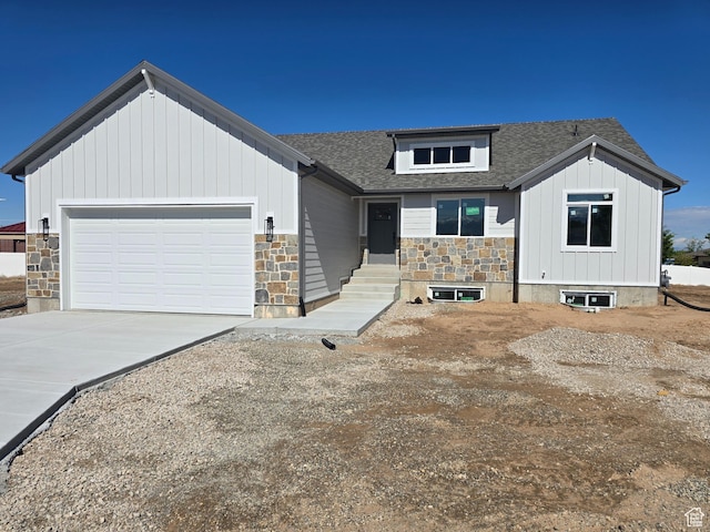 1928 W 1340 N, Clinton, UT 84015 - view of front of house with stone siding, board and batten siding, a garage, driveway, and roof with shingles