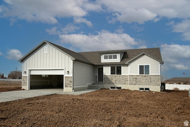 1928 W 1340 N, Clinton, UT 84015 - view of front of house featuring stone siding, an attached garage, board and batten siding, driveway, and roof with shingles