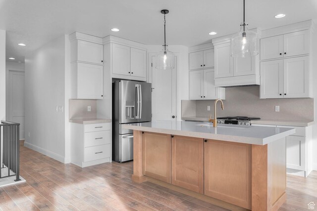 1137 W 2275 S, Syracuse, UT 84075 - kitchen featuring stainless steel refrigerator with ice dispenser, white cabinetry, and a kitchen island with sink