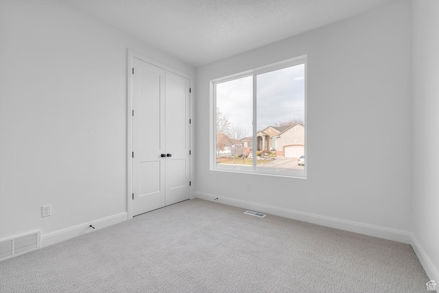 1137 W 2275 S, Syracuse, UT 84075 - unfurnished bedroom with light colored carpet, a textured ceiling, and a closet
