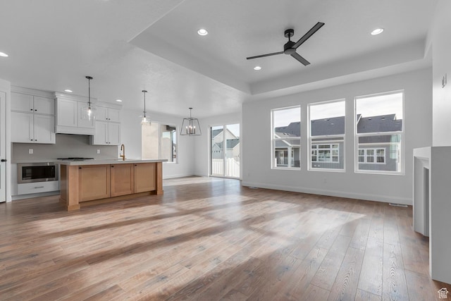 1137 W 2275 S, Syracuse, UT 84075 - kitchen with pendant lighting, light hardwood / wood-style flooring, appliances with stainless steel finishes, white cabinets, and a large island with sink