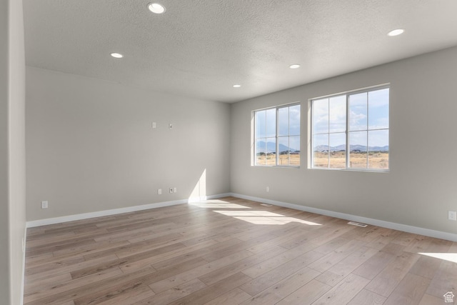 541 W Coyote Ridge Rd, Grantsville, UT 84029 - spare room with light hardwood / wood-style floors and a textured ceiling