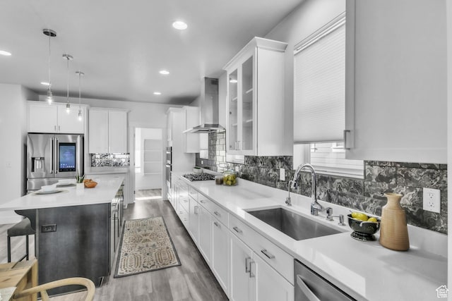 kitchen featuring stainless steel appliances, sink, white cabinets, and range hood
