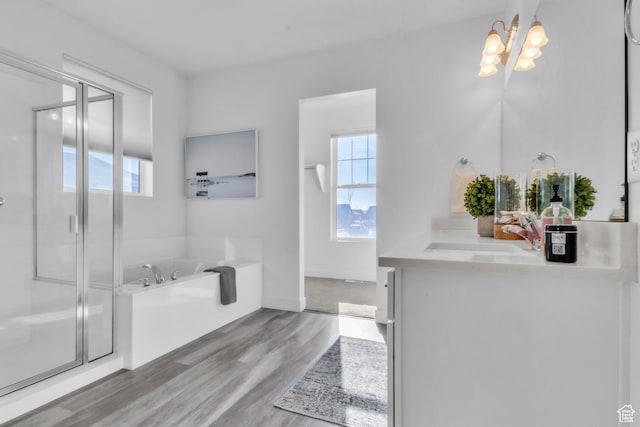 bathroom with vanity, shower with separate bathtub, a chandelier, and hardwood / wood-style floors