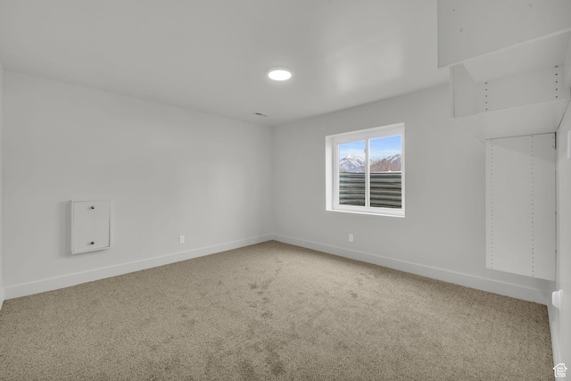 carpeted spare room with baseboards