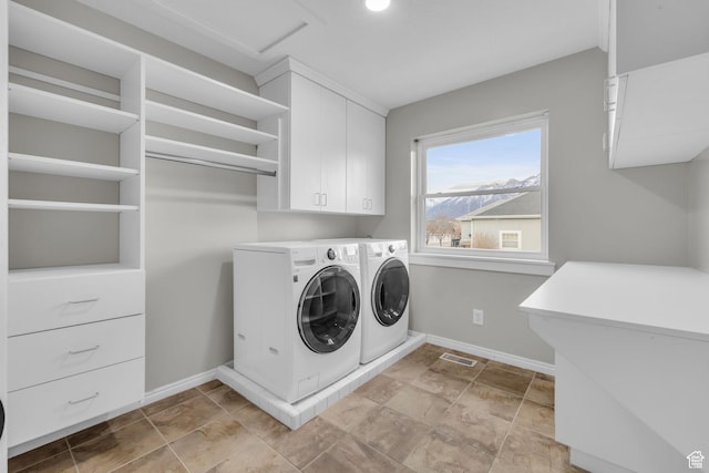 laundry area featuring washer and dryer, visible vents, baseboards, and cabinet space