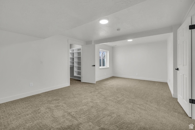 carpeted spare room featuring baseboards, recessed lighting, and a textured ceiling