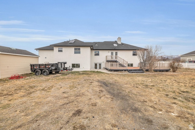 back of house featuring a deck and stucco siding
