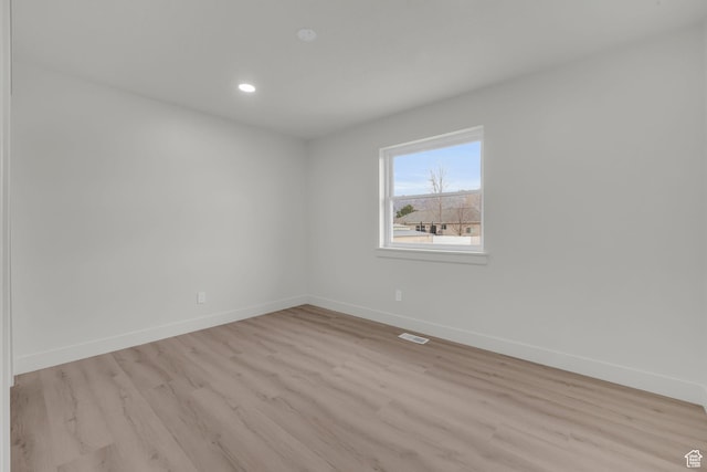 empty room with recessed lighting, light wood finished floors, visible vents, and baseboards