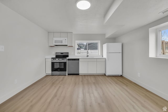 kitchen featuring white cabinetry, visible vents, stainless steel appliances, light wood finished floors, and baseboards