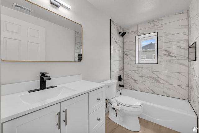full bath featuring vanity, toilet, visible vents, tub / shower combination, and wood finished floors