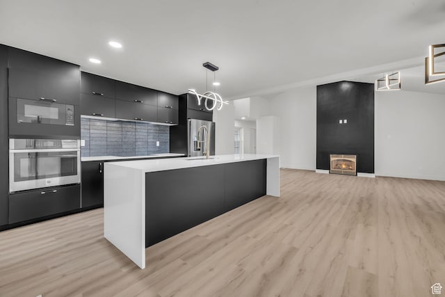 kitchen with modern cabinets, light countertops, dark cabinetry, and stainless steel appliances