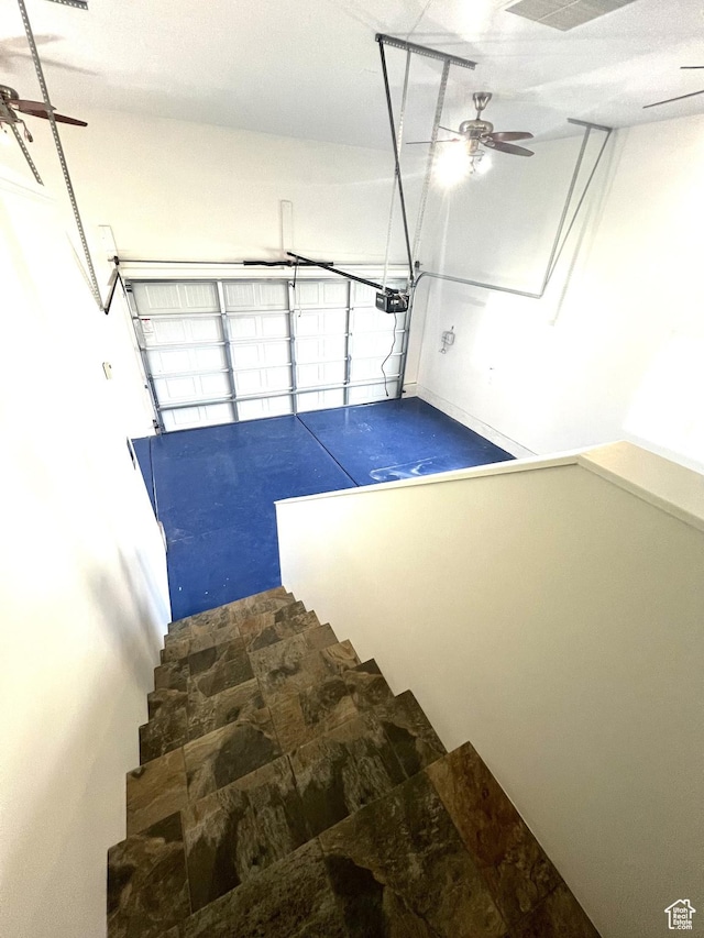 stairway featuring stone finish floor and ceiling fan