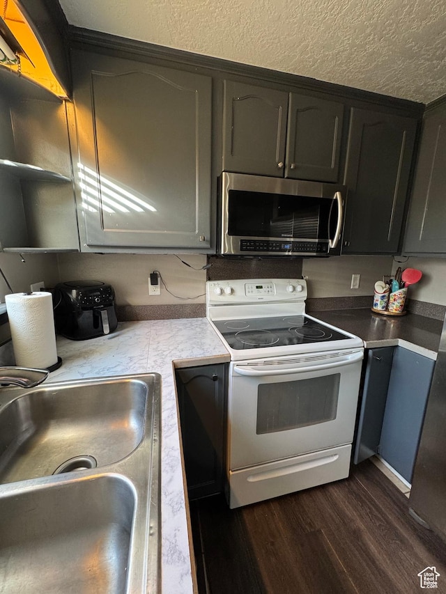 1050 S 500 W, Vernal, UT 84078 - kitchen featuring stainless steel microwave, electric range, dark wood-style flooring, a sink, and a textured ceiling
