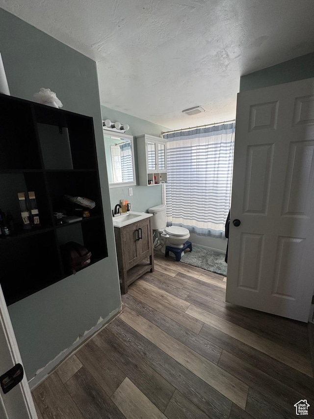 1050 S 500 W, Vernal, UT 84078 - full bath featuring wood finished floors, toilet, vanity, visible vents, and a textured ceiling