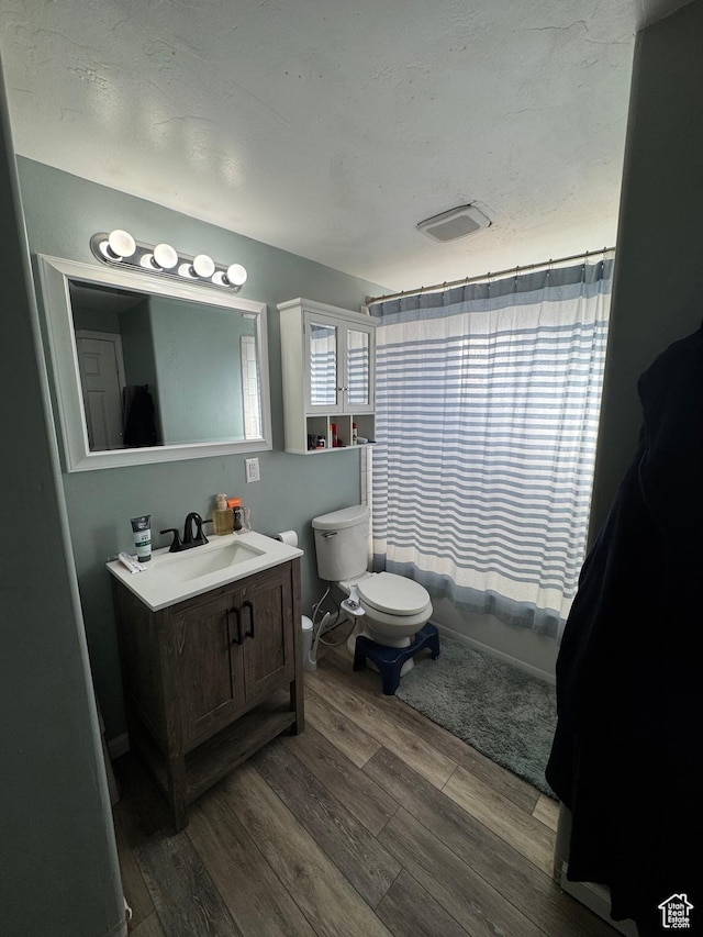 1050 S 500 W, Vernal, UT 84078 - full bathroom featuring shower / bath combo, vanity, toilet, visible vents, and wood finished floors