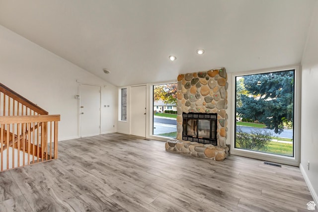 2573 Jordan Meadows Ln, West Jordan, UT 84084 - unfurnished living room with a fireplace, vaulted ceiling, and light wood-type flooring