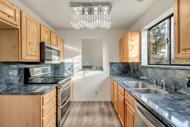 2573 Jordan Meadows Ln, West Jordan, UT 84084 - kitchen with sink, decorative backsplash, hanging light fixtures, stainless steel appliances, and light hardwood / wood-style flooring