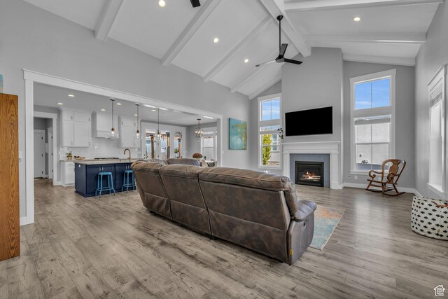 1932 W 200 N, Kaysville, UT 84037 - living room featuring ceiling fan with notable chandelier, sink, high vaulted ceiling, beamed ceiling, and light hardwood / wood-style floors